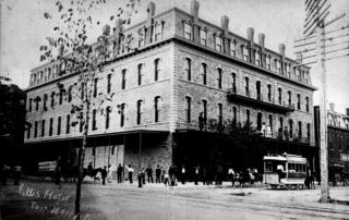 black & white photograph of old building at corner of street intersection