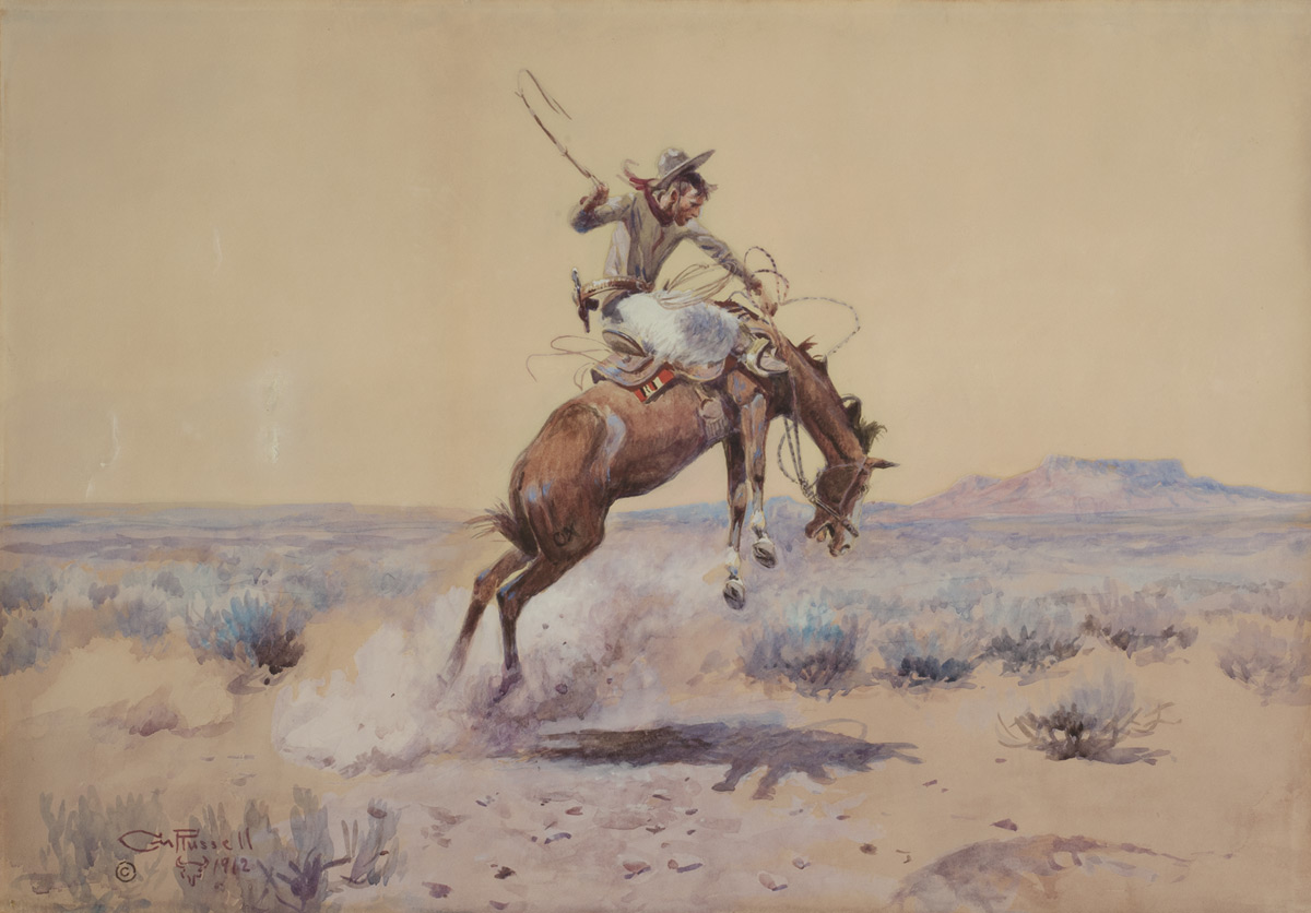 A cowboy rides a bucking horse in an open landscape.