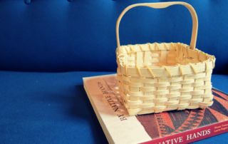 a woven basket on top of a book about Native American basketry