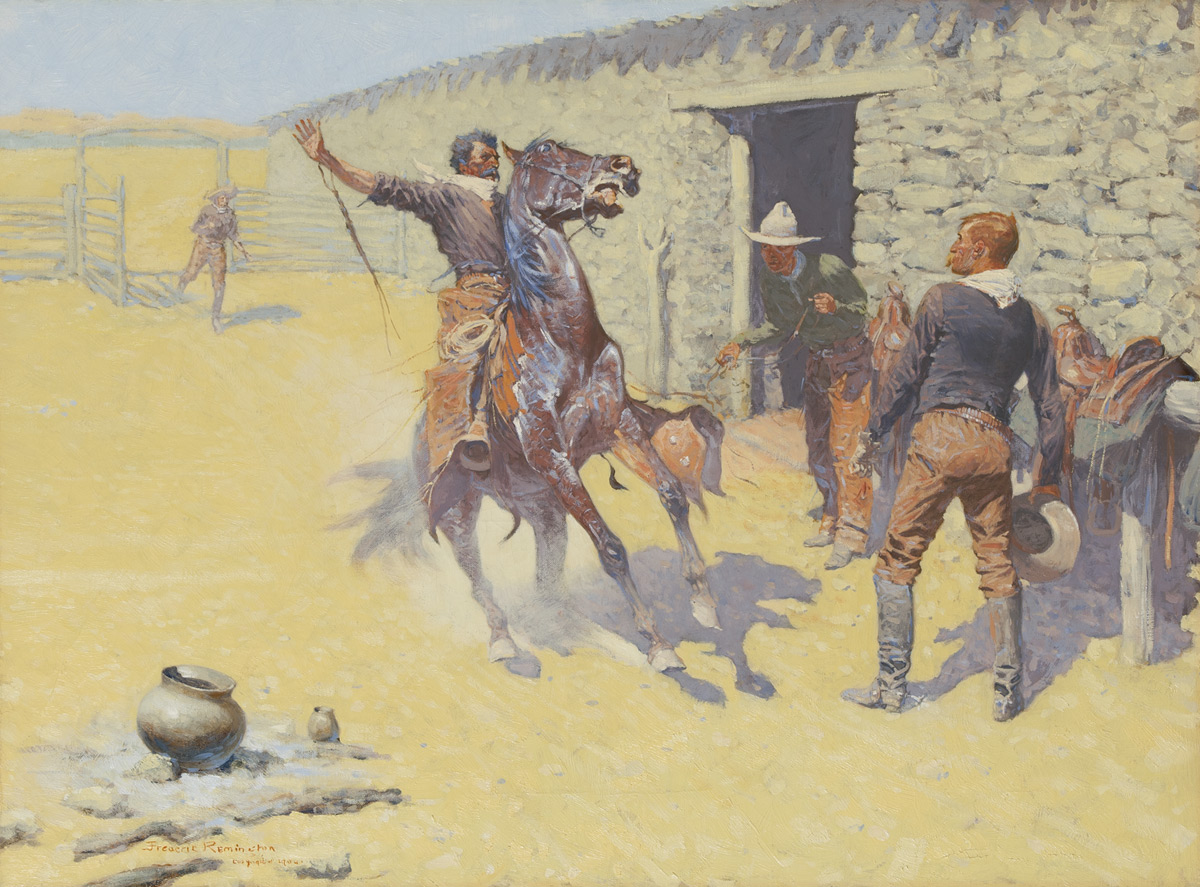 A cowboy on horseback comes to a halt with his hand in the air in front of two standing cowboys.