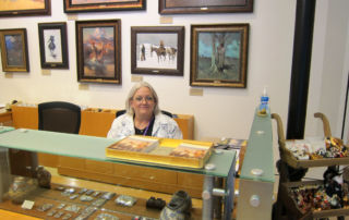 a woman seated at front desk of art museum