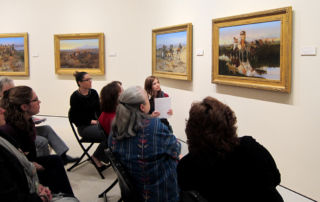 group of seated adults all looking at one painting