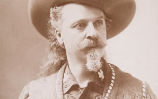 portrait of Anglo man with mustache and goatee wearing a leather vest with fringe
