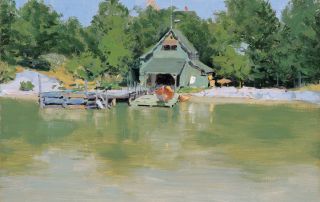 boathouse on a lake in front of trees