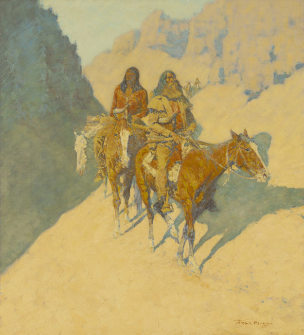 An Anglo man and an indigenous American ride horses through a shadowed canyon.
