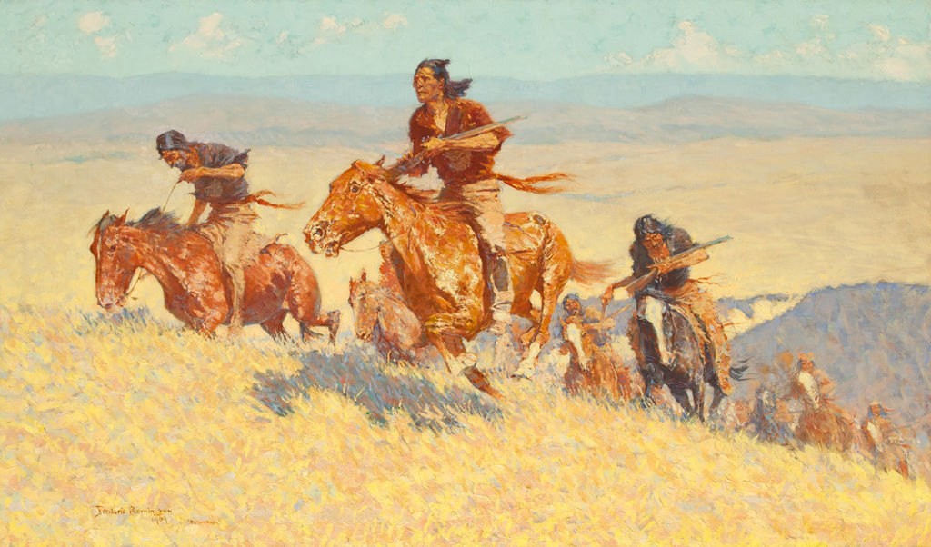 A group of indigenous American men holding rifles gallop up a hill on horseback.