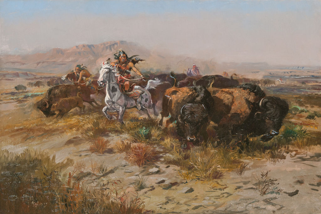 An indigenous American man on horseback aims his bow and arrow at a bison with other indigenous American hunters and bison in the background.