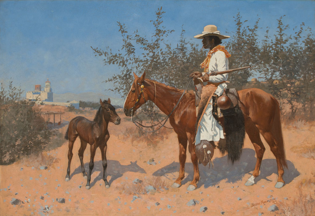A man rides a brown horse with a city in the background.