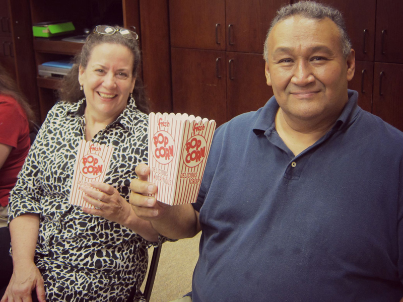 a couple holding popcorn boxes