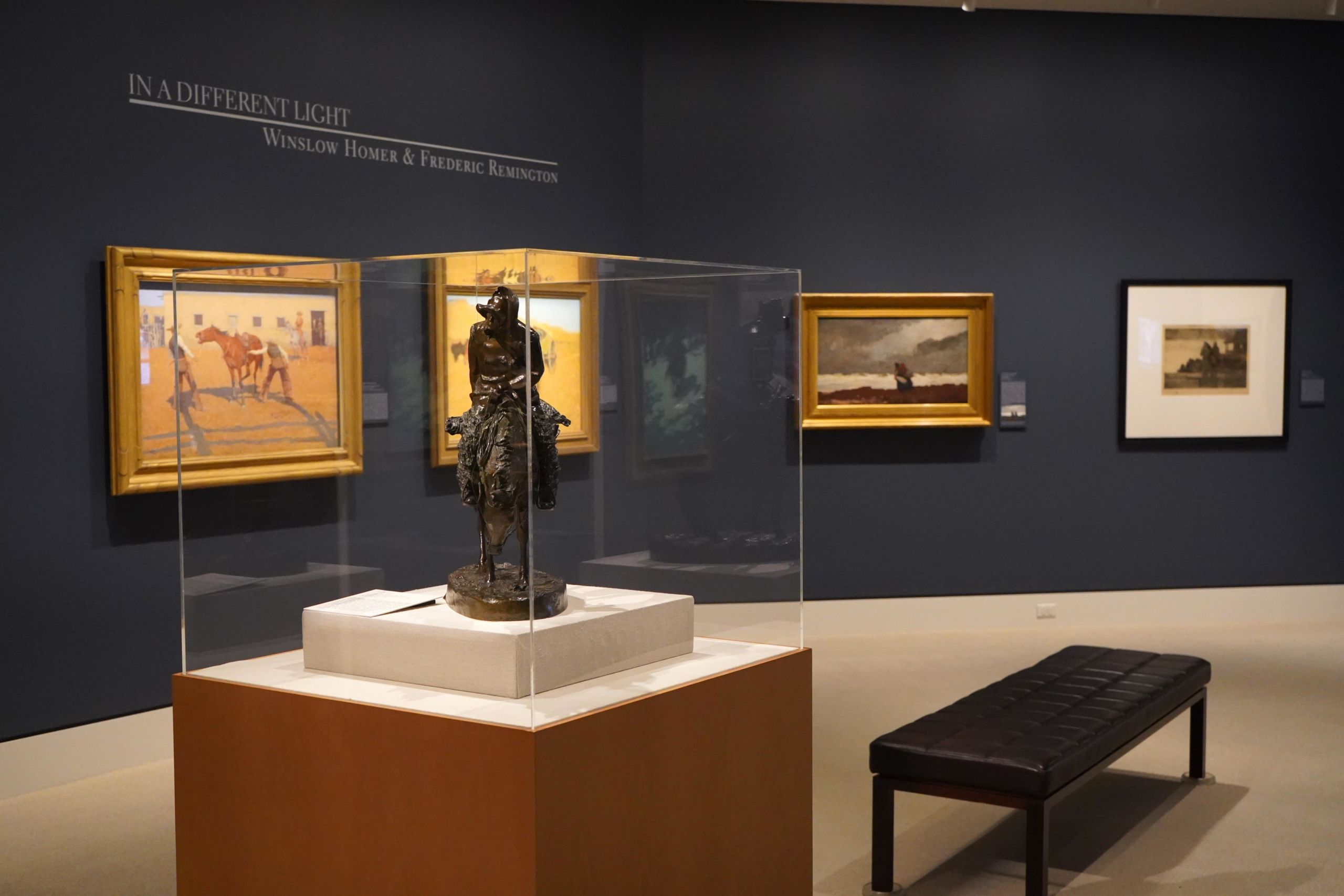 view of installation of art exhibit featuring Frederic Remington and Winslow Homer