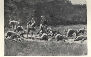 A group of military men taking cover on ground in an open landscape