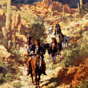 Group of Native Americans dressed in Western-style cloths riding and walking horses through a southwest landscape