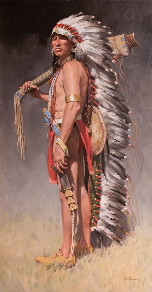 Native American man standing with long feathered headdress