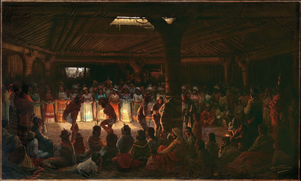 A group of Native Americans dancing inside a roundhouse 