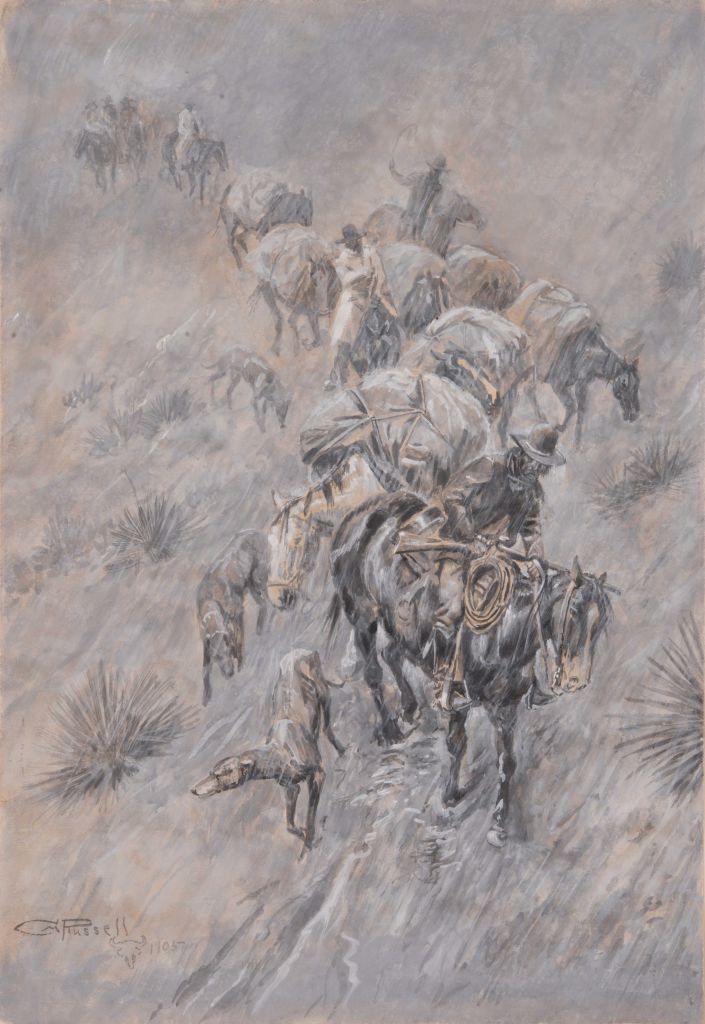 A pack train of horses and their riders traveling down a hill through hard rain.