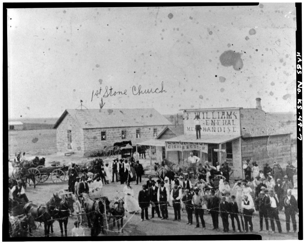 Crowds of Black people posing in front of general store in an old town.