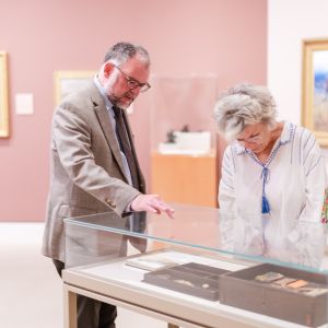 Woman looking at something in glass case at which a man is pointing.