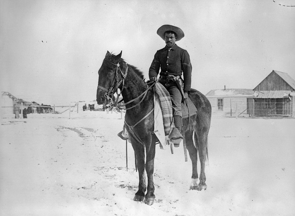 Black soldier sitting on a horse.