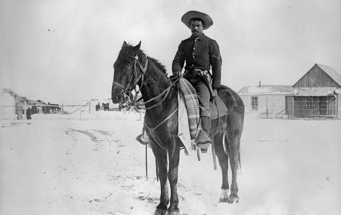 Black soldier sitting on a horse.