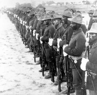 A line of black soldiers standing with rifle in hand.