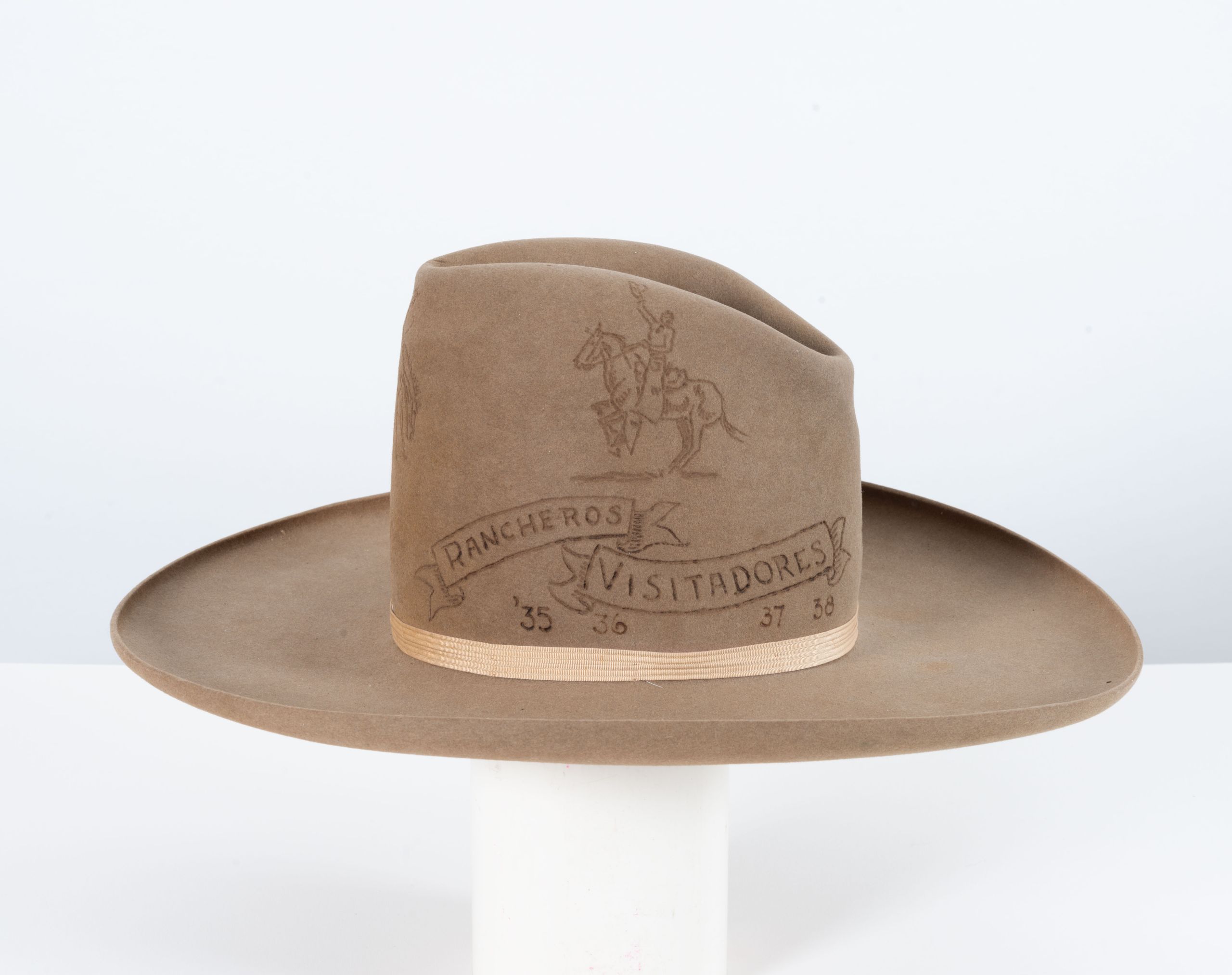 a cowboy hat with designed etched into the top