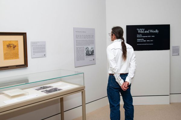 A man reading an exhibit label in an art museum.