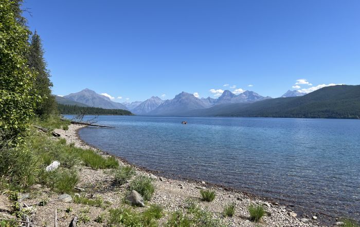 shoreline of a lake with mountains in background